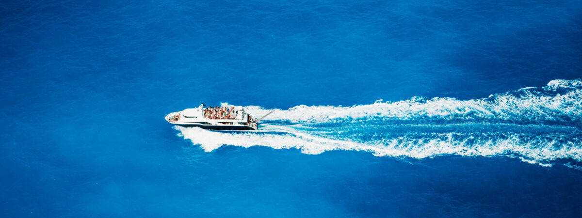 Top view of tourist boat sailing in the sea on full speed.